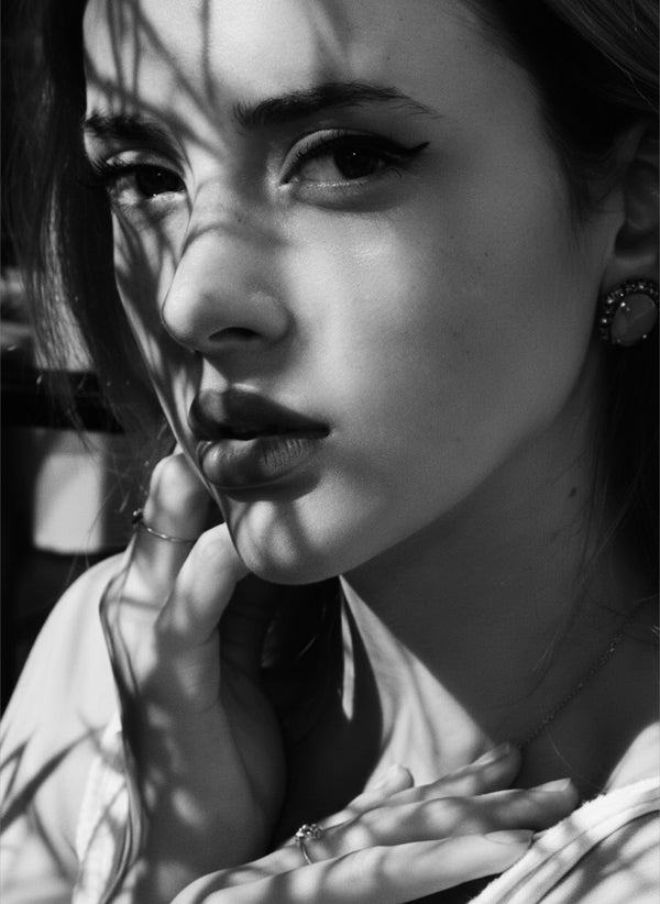 Black and white portrait of a woman with her hand at her face in dramatic light, fine art portrait NYC