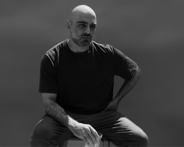 Black and white portrait of a man in a T-shirt, relaxed seated studio portrait in New York