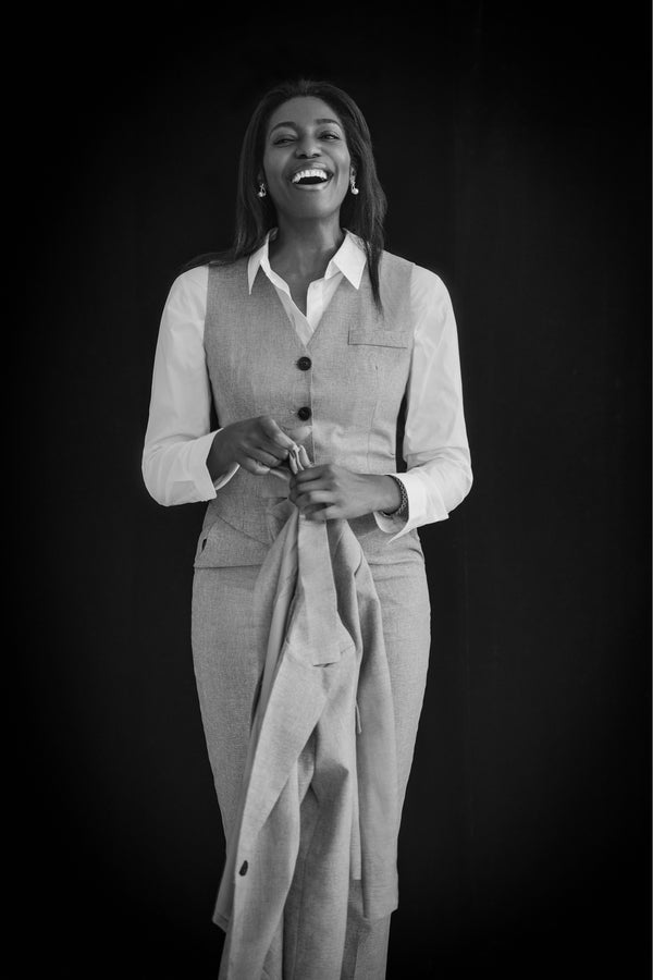 Full-length portrait of a woman in a white blouse and trousers on a black backdrop, NYC portrait photographer