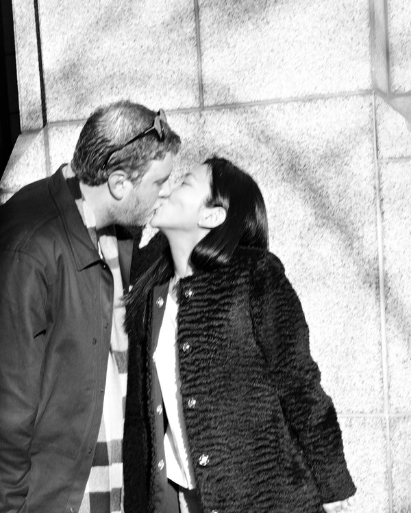 Couple kissing against a stone wall in black and white, NYC engagement photographer Lena Di
