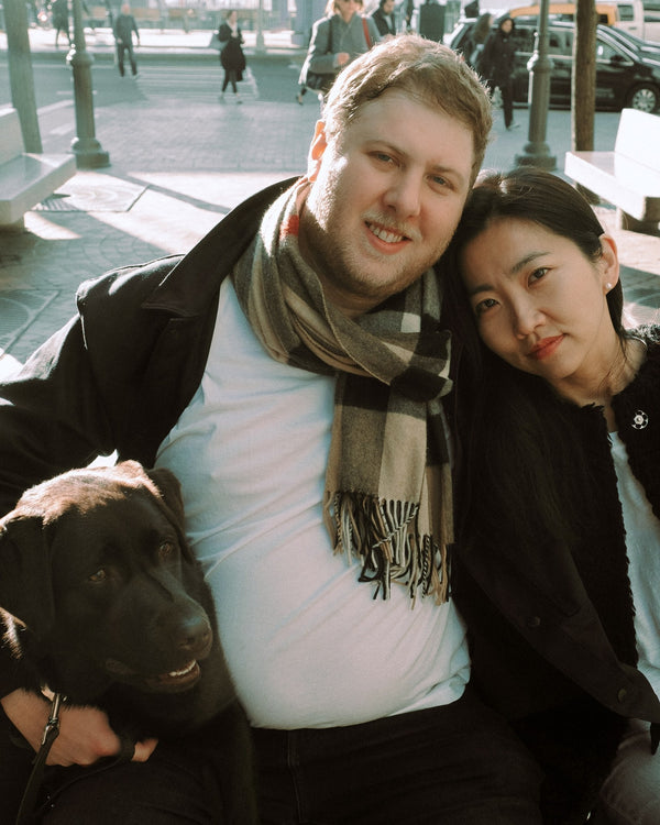 Couple cuddling with their dog on a New York plaza, candid NYC couples portrait