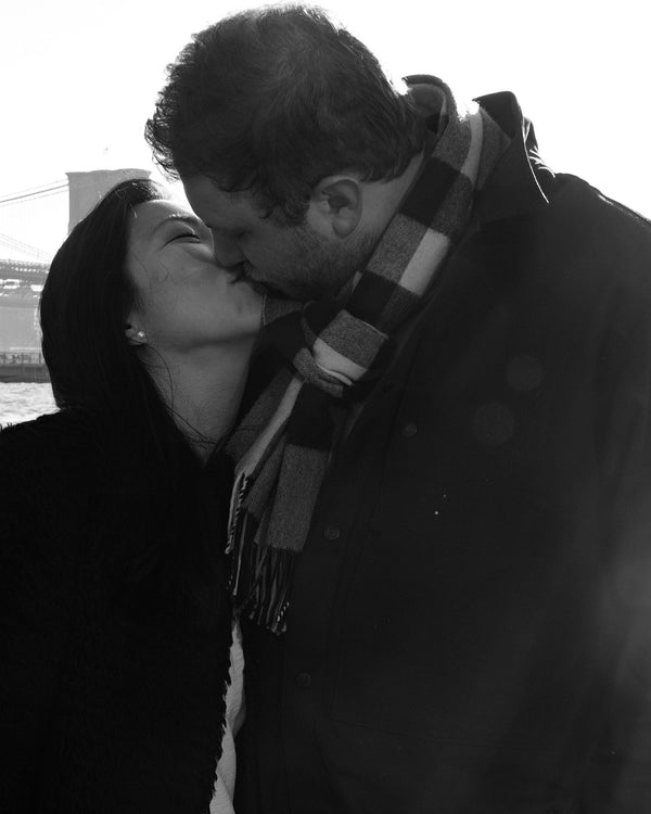 Close black and white portrait of a couple kissing in winter coats, NYC engagement photographer