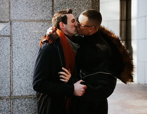 Couple kissing against a stone wall on a winter day in Manhattan, NYC couples photography by Lena Di