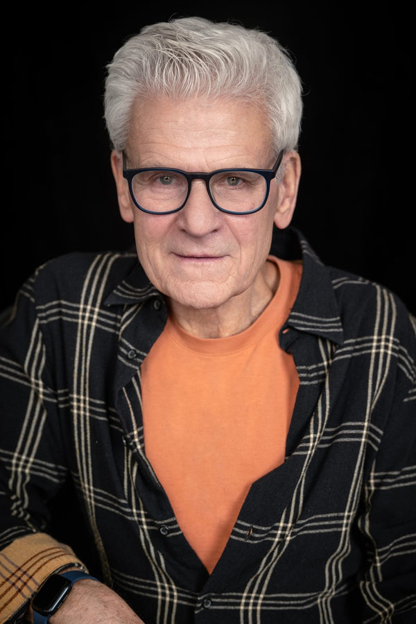 NYC headshot photographer – LinkedIn headshot on black backdrop, man in glasses and plaid shirt