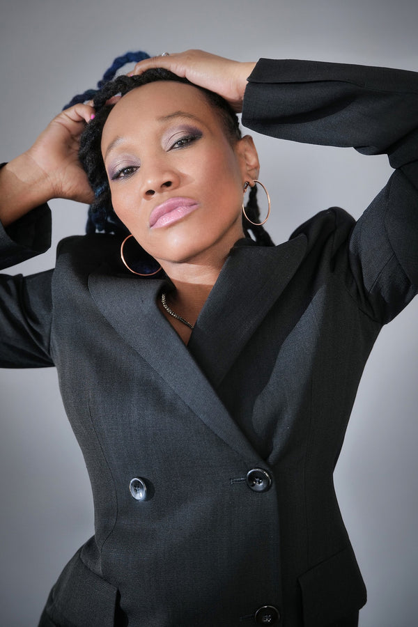 Model in a black double-breasted blazer with hands behind her head, NYC model portfolio by Lena Di