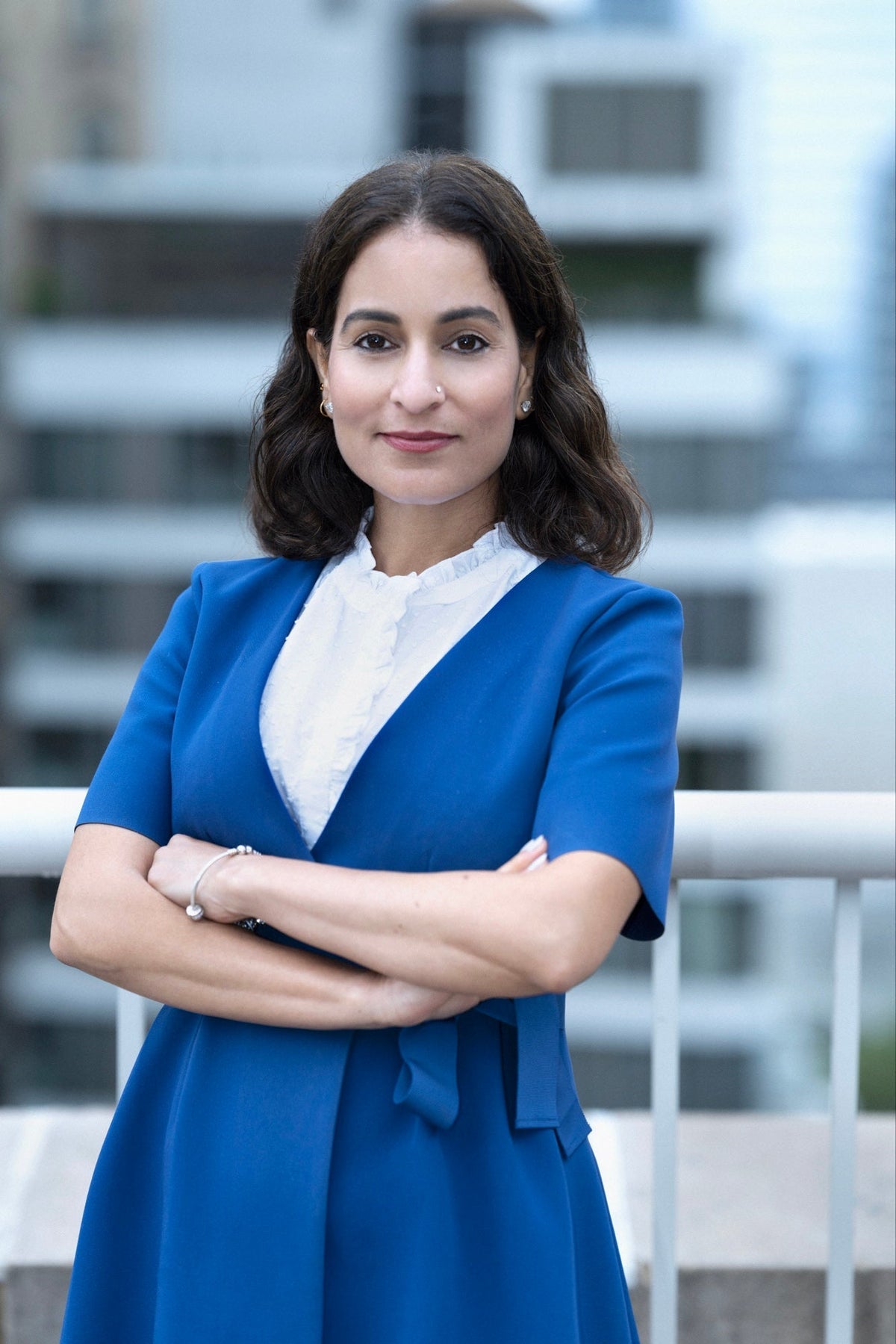 Professional woman in blue business attire, arms crossed, corporate headshot by NYC photographer Lena Di