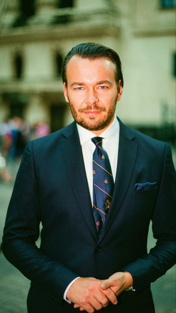 Young man in a navy suit and tie on a New York street, professional portrait by Lena Di