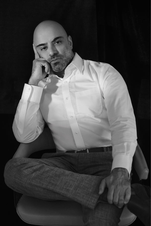 Black and white portrait of a man in a white shirt seated in the studio, NYC portrait photographer