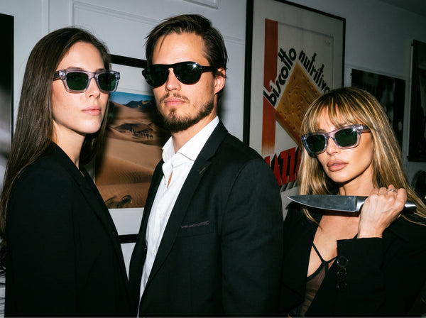 Group portrait of three friends in sunglasses against a gallery wall, New York portrait session