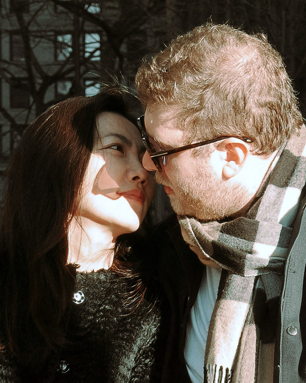 Close-up of a couple nose to nose in winter scarves, NYC engagement photographer Lena Di