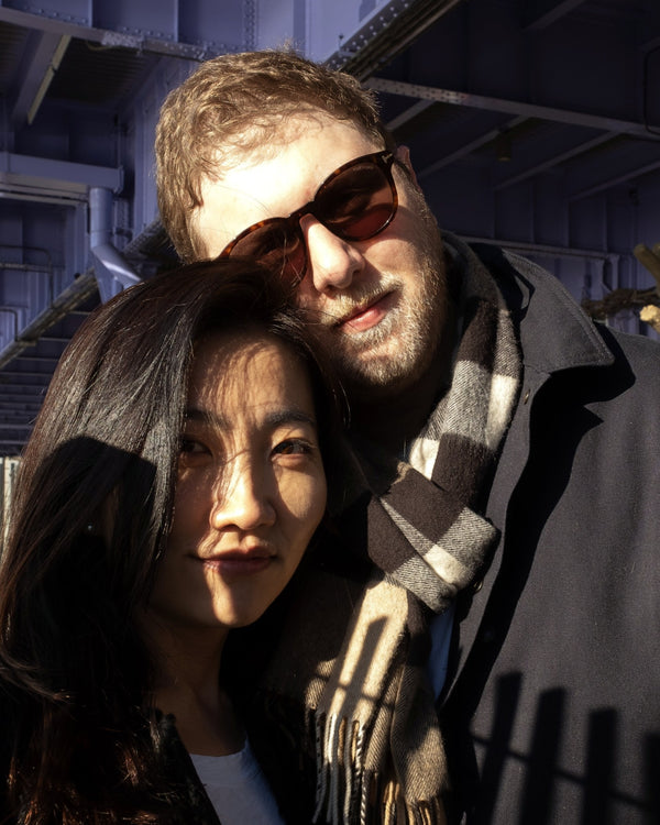 Couple in sunglasses and a plaid scarf in golden winter sun, NYC engagement photographer Lena Di