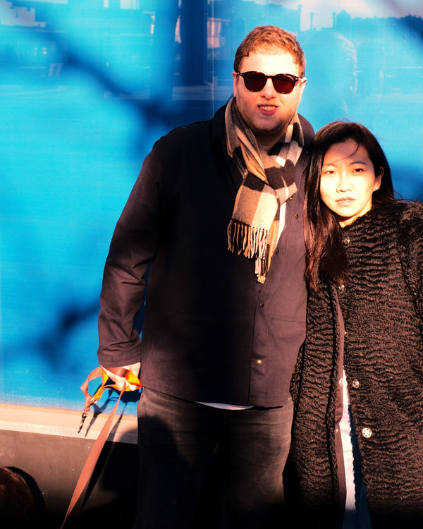 Couple with their dog against a bright blue wall in New York, NYC couples session by Lena Di