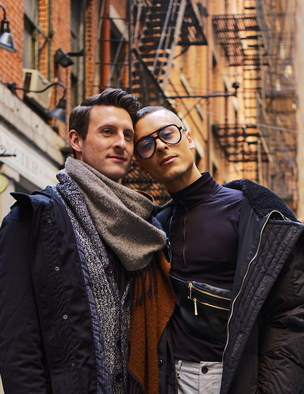 Couple posing together in front of fire escapes on a red-brick New York street, NYC couples photography by Lena Di