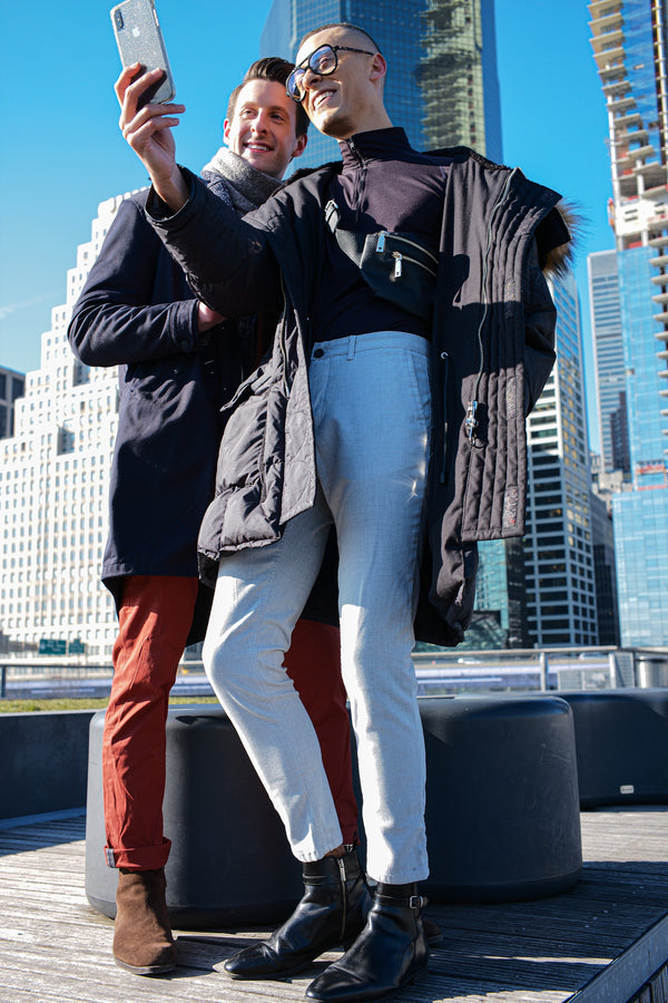 Couple taking a selfie on a Manhattan rooftop with skyscrapers and blue sky, NYC couples photographer Lena Di