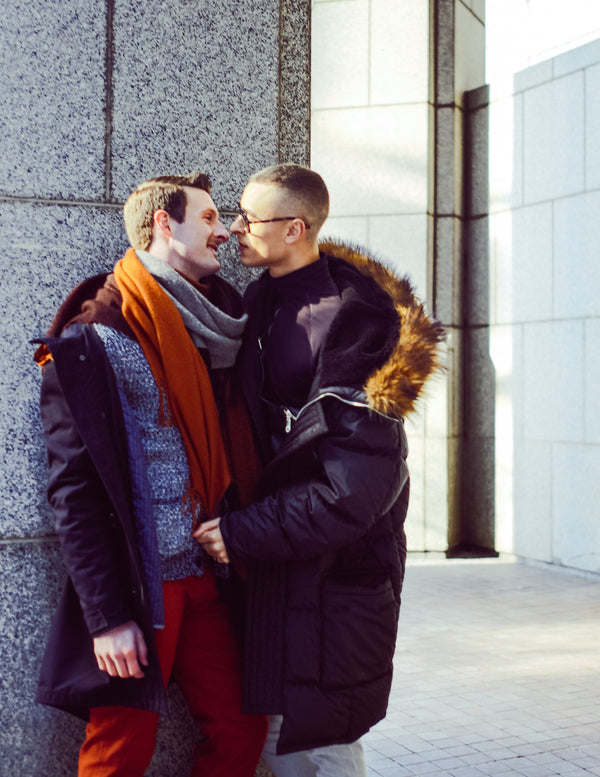 Couple embracing by a stone building in Lower Manhattan, NYC couples photographer Lena Di