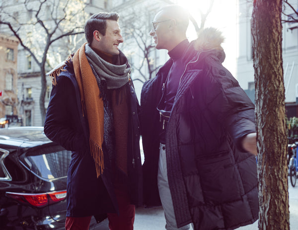 Couple laughing together in winter sun on a tree-lined New York street, NYC couples photographer Lena Di