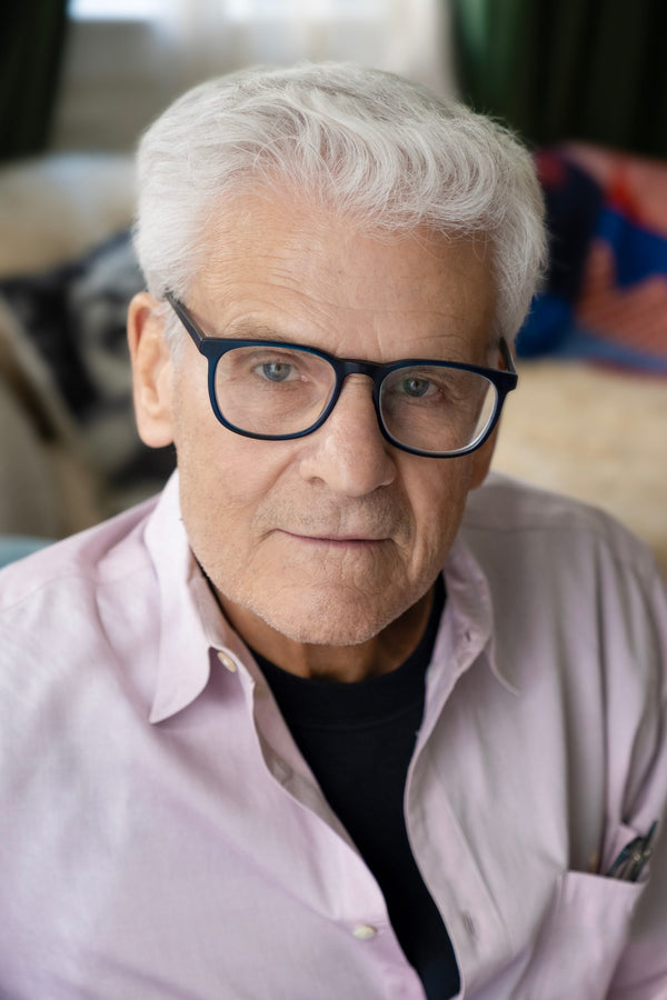 Environmental headshot at home – man in glasses and pink shirt, NYC headshot photographer Lena Di